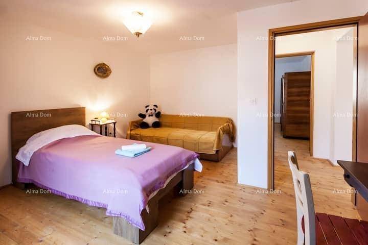 Freundliches Schlafzimmer mit Einzelbett, Sofa und hellem Holzfußboden.