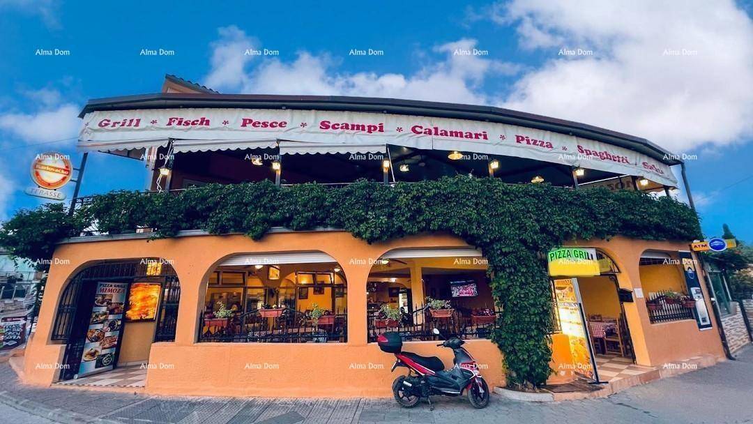 Breite Außenansicht des Restaurants mit Markise und üppiger Begrünung an der Fassade.