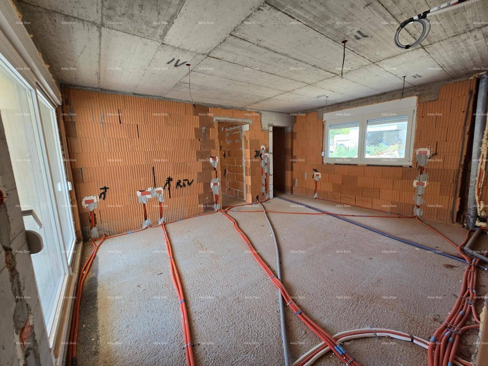 Rohbau eines Zimmers mit Fenster, unverputzten Ziegelwänden und vorbereiteten Elektroinstallationen.