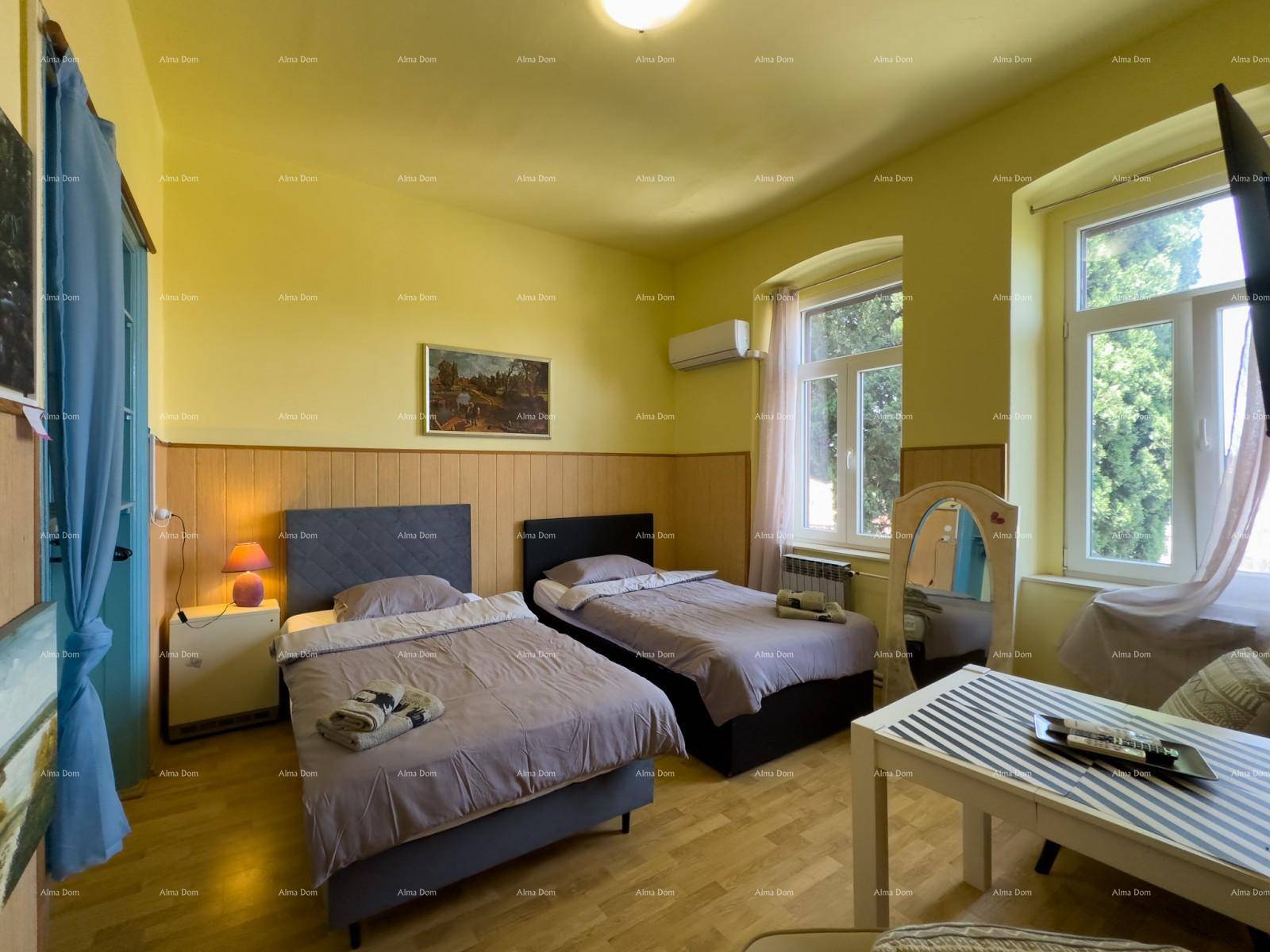 Helles Schlafzimmer mit zwei Einzelbetten, Holzboden und gelben Wänden, inklusive Klimaanlage.