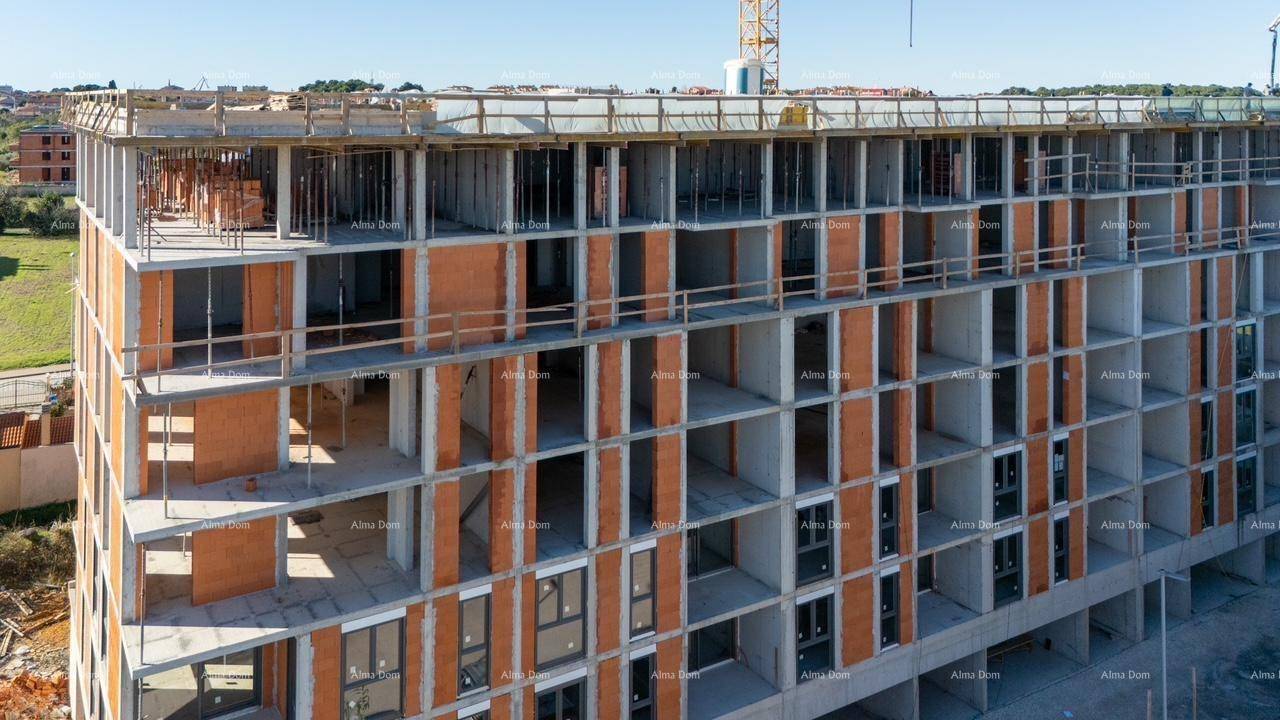 Detaillierte Ansicht der im Bau befindlichen Fassade mit den strukturellen Elementen und Fensteröffnungen.