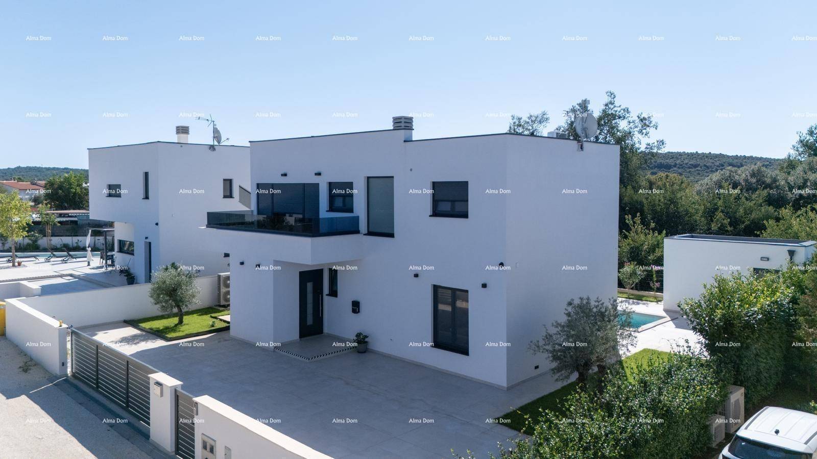 Zwei moderne weiße Villen mit Flachdächern, großen Fenstern und gepflegten Außenbereichen.