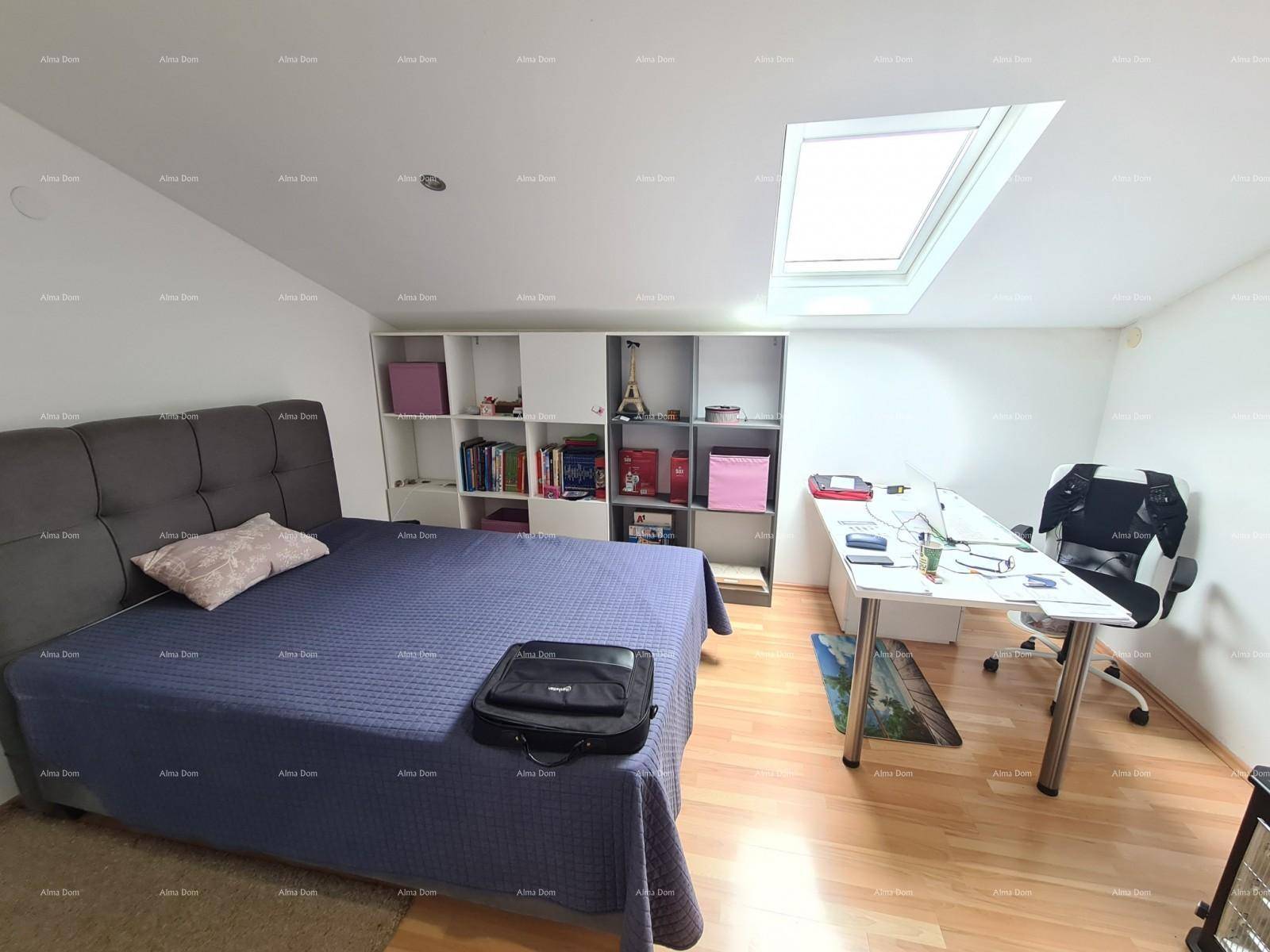 Schlafzimmer im Dachgeschoss mit Holzboden, Dachfenster und integriertem Arbeitsbereich.