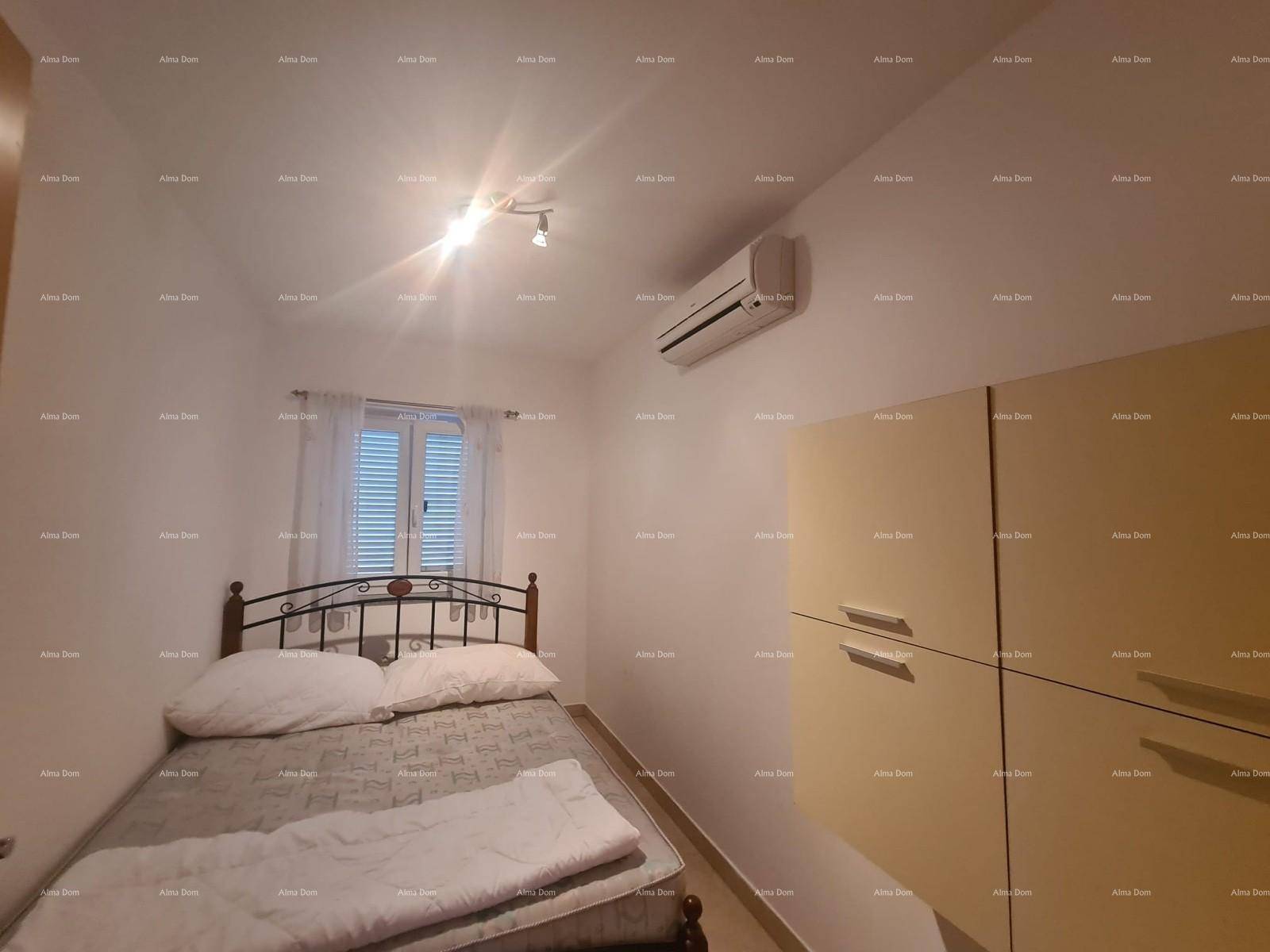 Schlafzimmer mit Doppelbett, Klimaanlage und einem Fenster mit Jalousien.