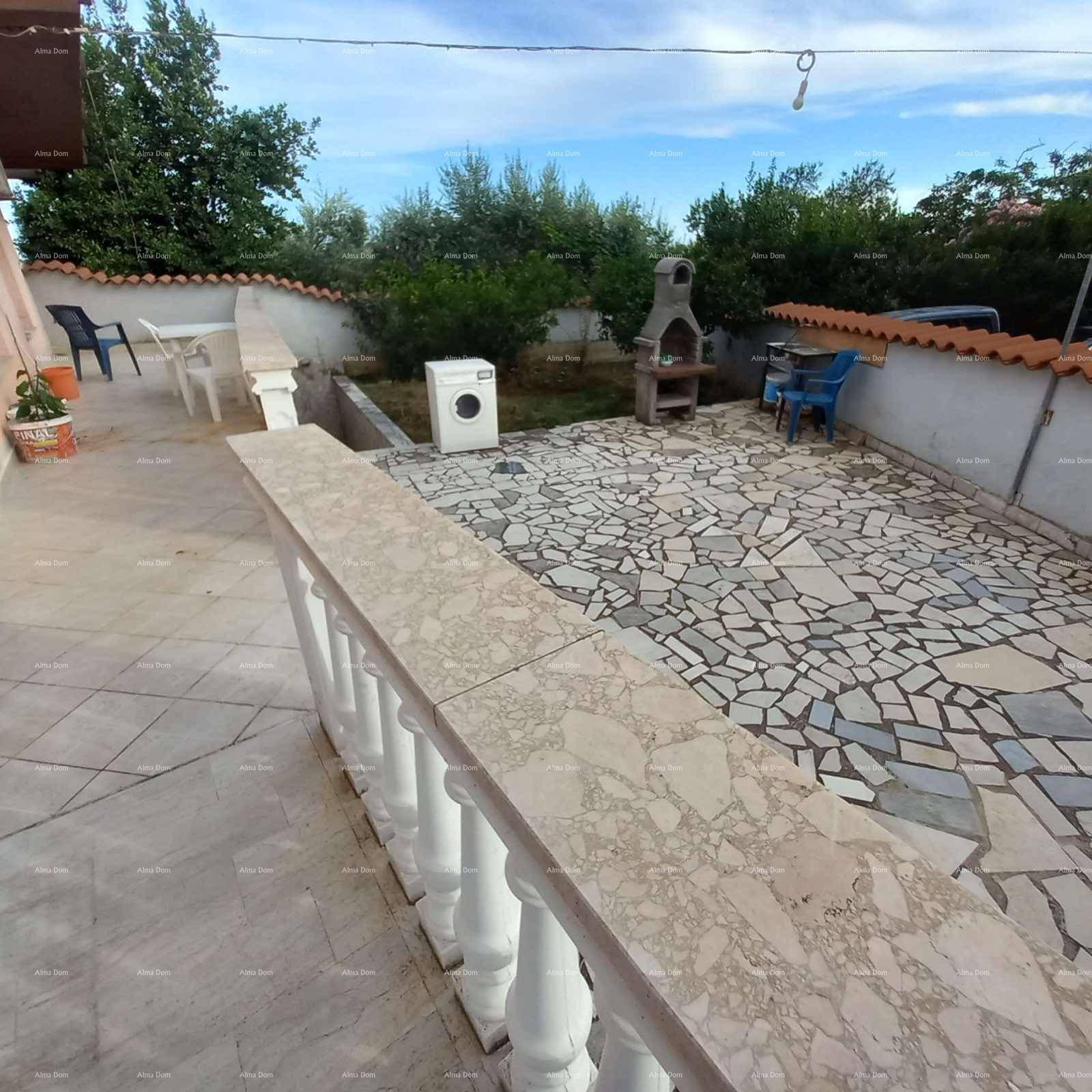 Große geflieste Terrasse mit Grillplatz und Gartenmöbeln, ideal für Mahlzeiten im Freien.