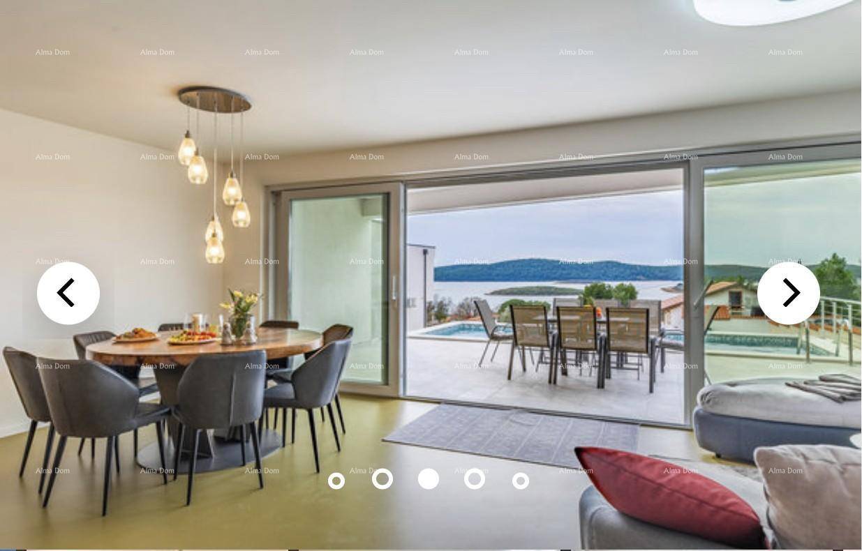 Heller Essbereich mit großem Holztisch und direktem Zugang zur Terrasse mit Meerblick.
