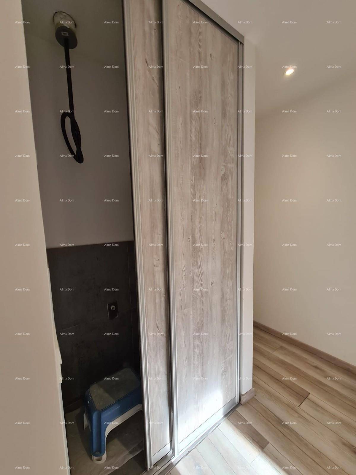 Kleiner Abstellraum hinter Schiebetüren mit einem Boiler und Stauraum.
