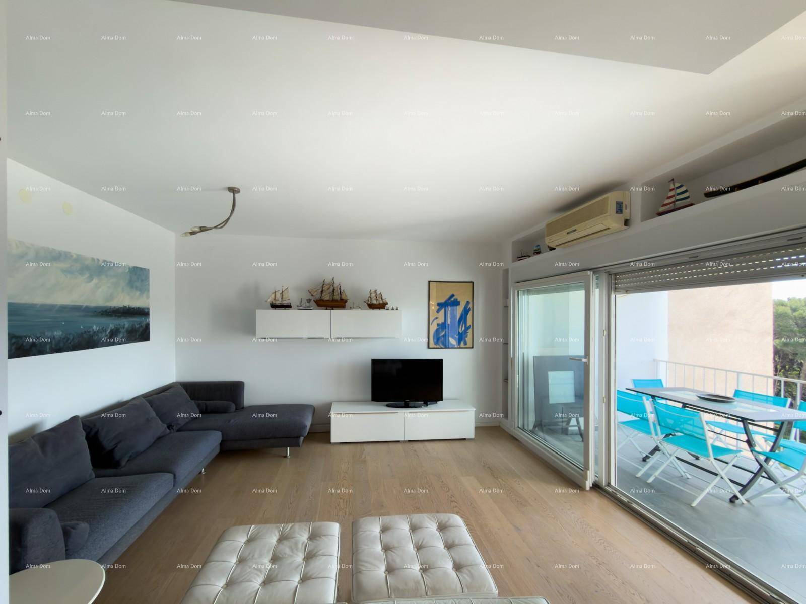 Geräumiges Wohnzimmer mit bequemer Couch, Holzboden und Zugang zu einem sonnigen Balkon.