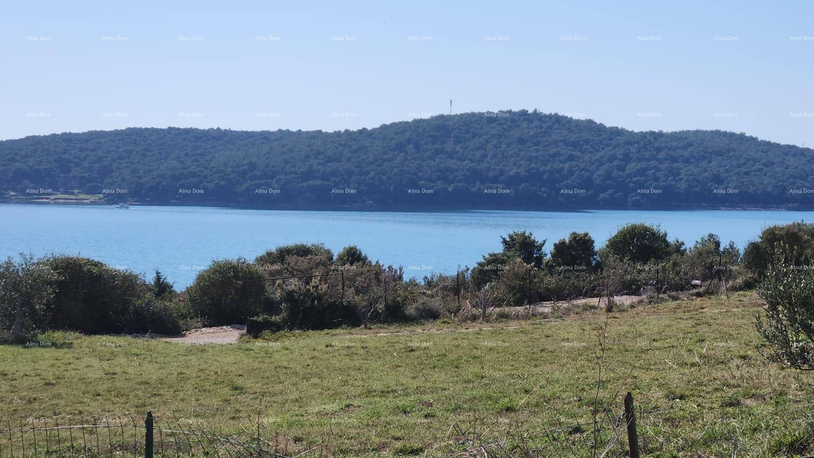 Weitläufiger Blick auf das Meer und bewaldete Hügel in der Ferne.