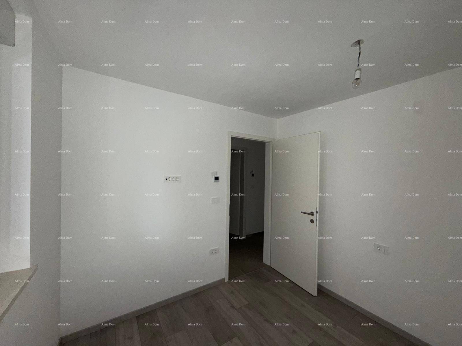 Helles, leeres Schlafzimmer mit Holzboden und weiß gestrichenen Wänden.