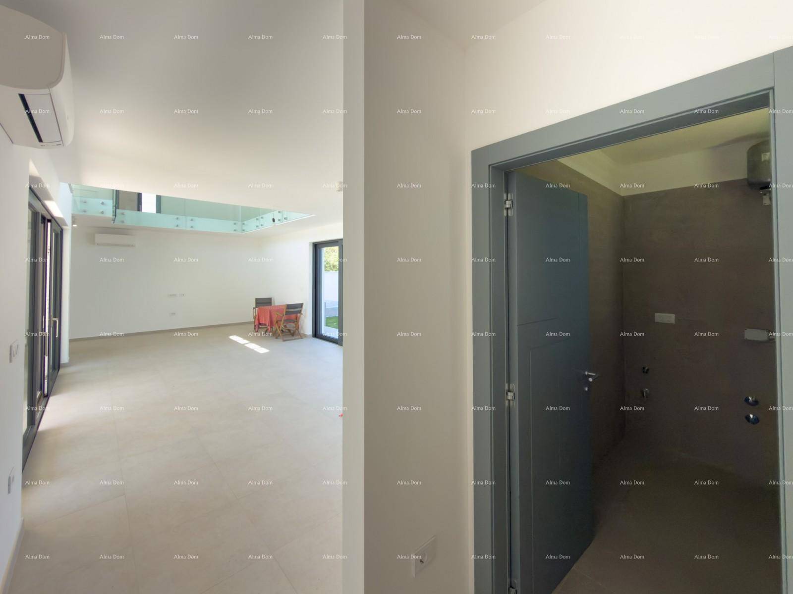 Blick vom Wohnbereich in einen gefliesten Hauswirtschaftsraum mit Anschlüssen.