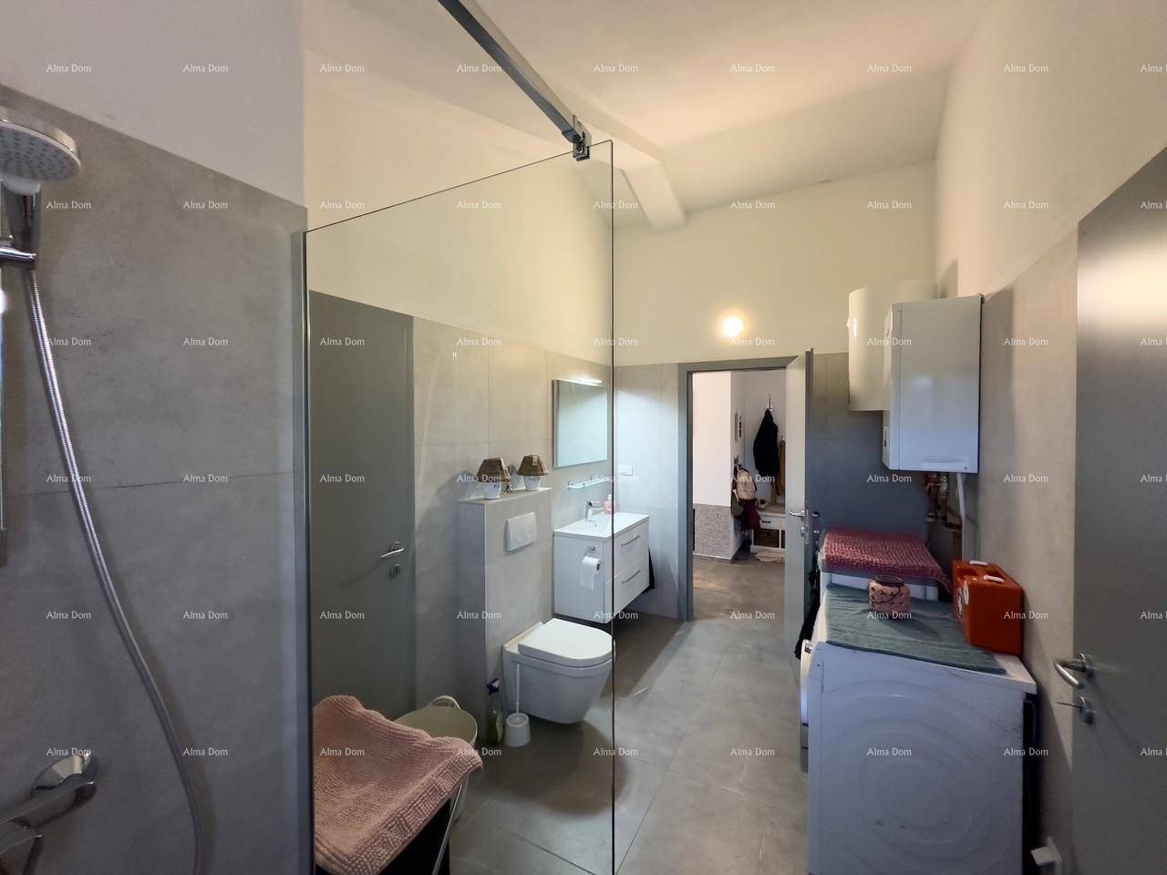 Geräumiges Badezimmer mit Duschkabine, WC und Waschmaschine, angrenzend an einen Flur.