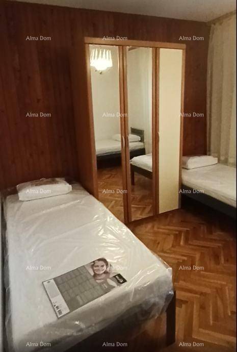 Schlafzimmer mit Einzelbett, Parkettboden und einem großen Spiegelschrank.