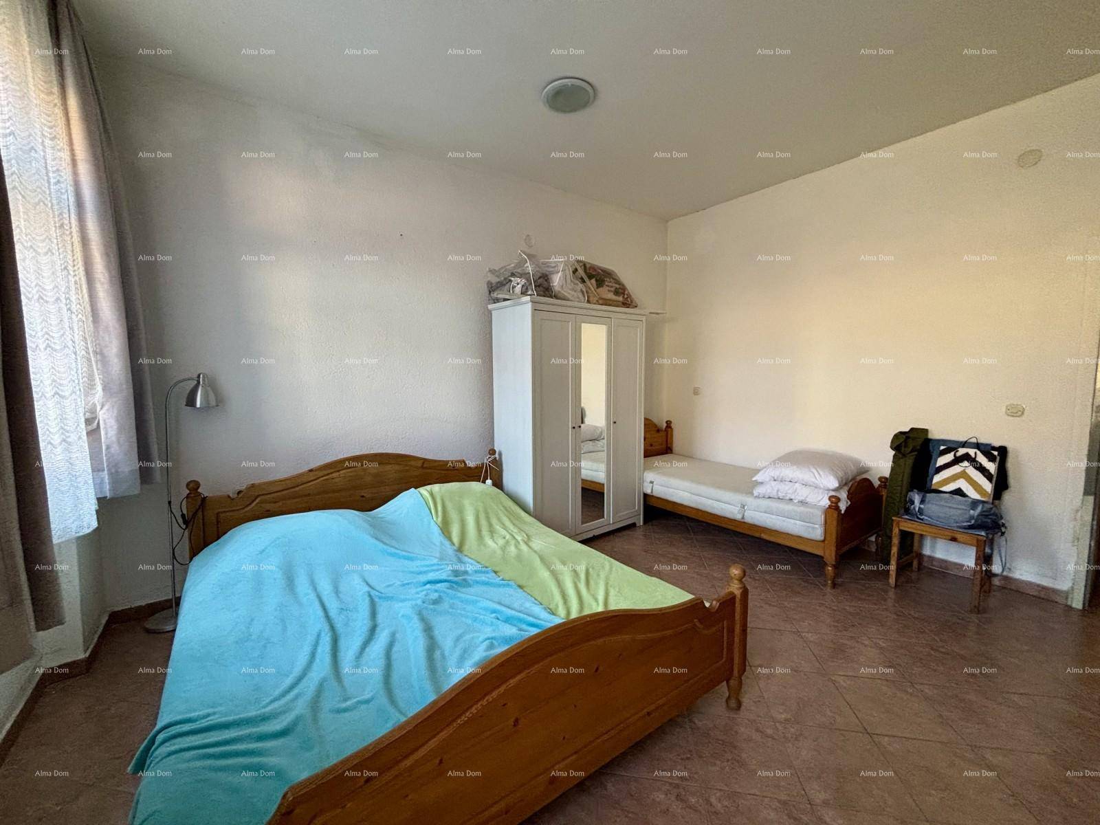 Helles Schlafzimmer mit zwei Einzelbetten, einem weißen Kleiderschrank und einfacher Einrichtung.