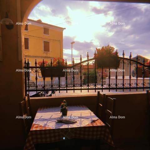 Gemütlicher Essbereich mit karierter Tischdecke und Blick auf den Sonnenuntergang über den Dächern.