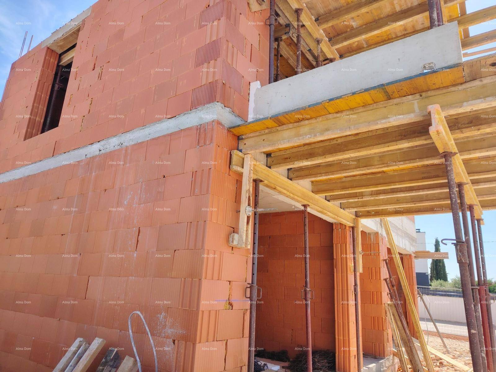 Detailansicht des Rohbaus mit Ziegelmauerwerk und Holzschalung für die Deckenkonstruktion.