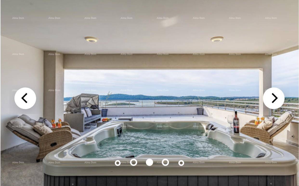 Großer Whirlpool auf der Terrasse mit Meerblick und bequemen Rattanmöbeln.