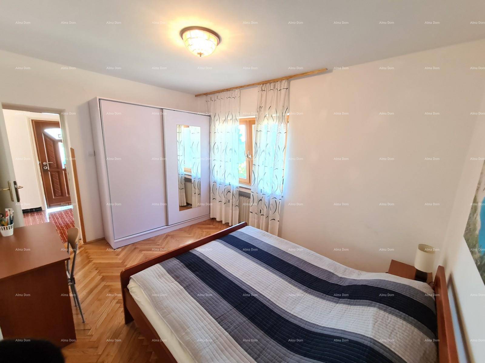 Schlafzimmer mit Parkettboden, Doppelbett und weißem Schiebetürenschrank.