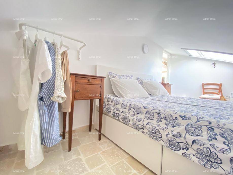 Schlafzimmer unter der Dachschräge mit Doppelbett, Nachttisch und offener Kleiderstange.