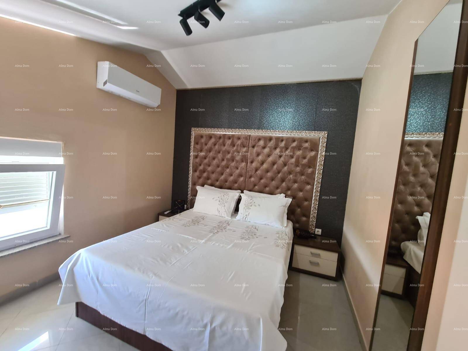 Schlafzimmer mit großem Bett, gepolstertem Kopfteil und Klimaanlage an der Wand.