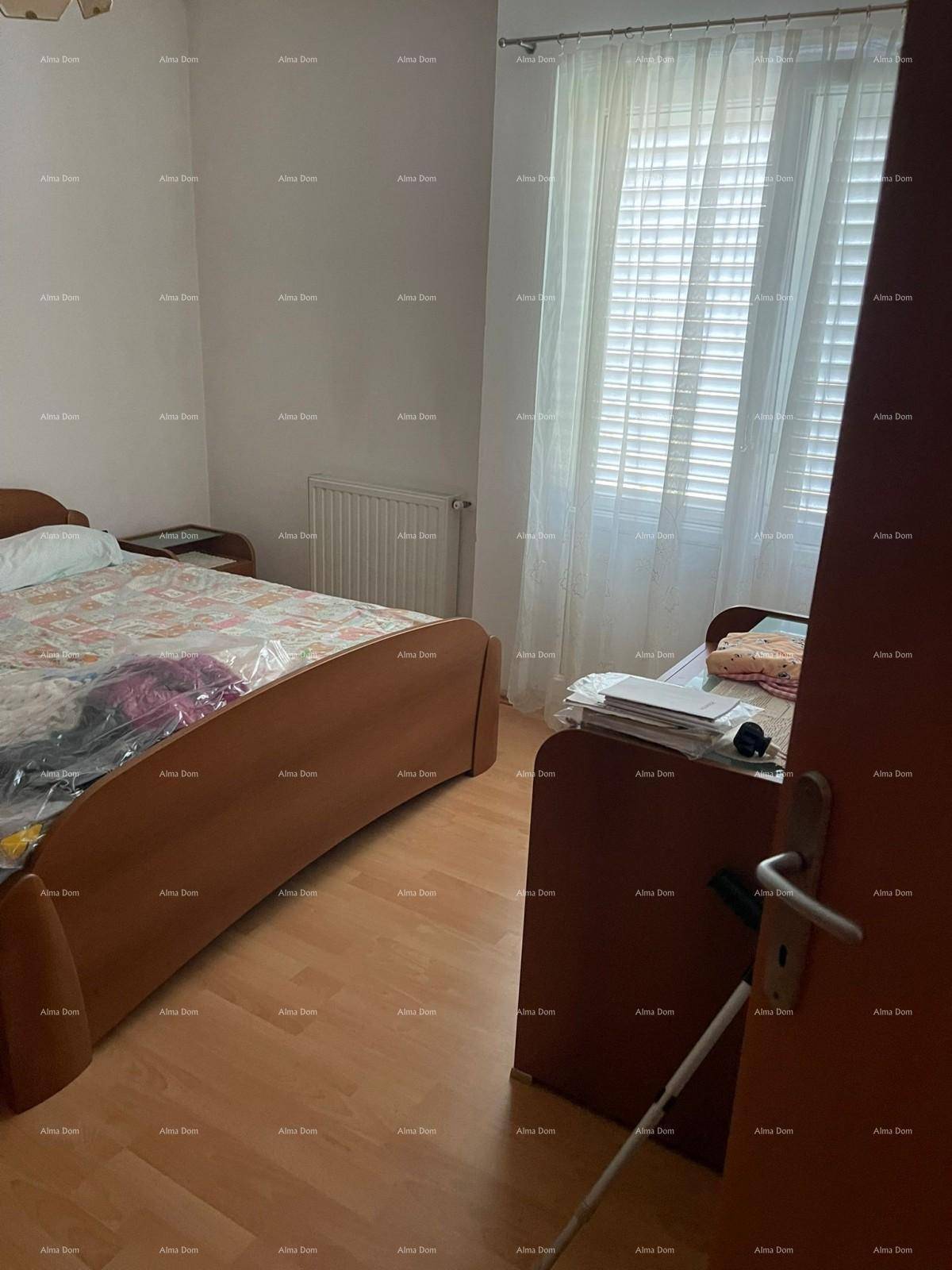 Schlafzimmer mit Doppelbett, Einzelbett, Holzfußboden und einem Fenster mit Jalousien für Privatsphäre.