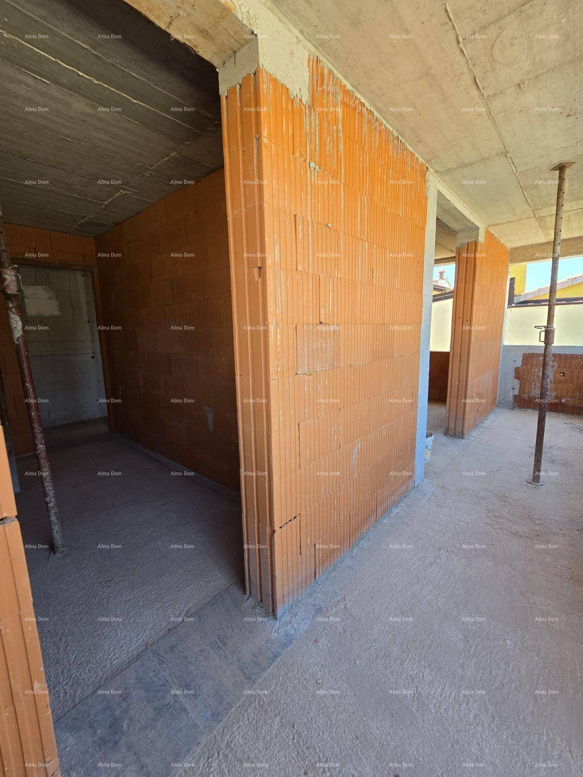 Rohbau eines Raumes mit Ziegelwänden und Betonstützen, der Boden ist noch unfertig.