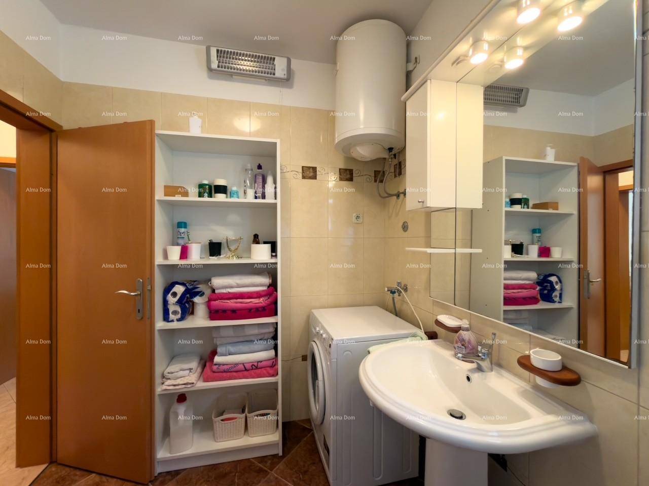 Badezimmer mit Waschbecken, Spiegel und offenem Regal für Handtücher.