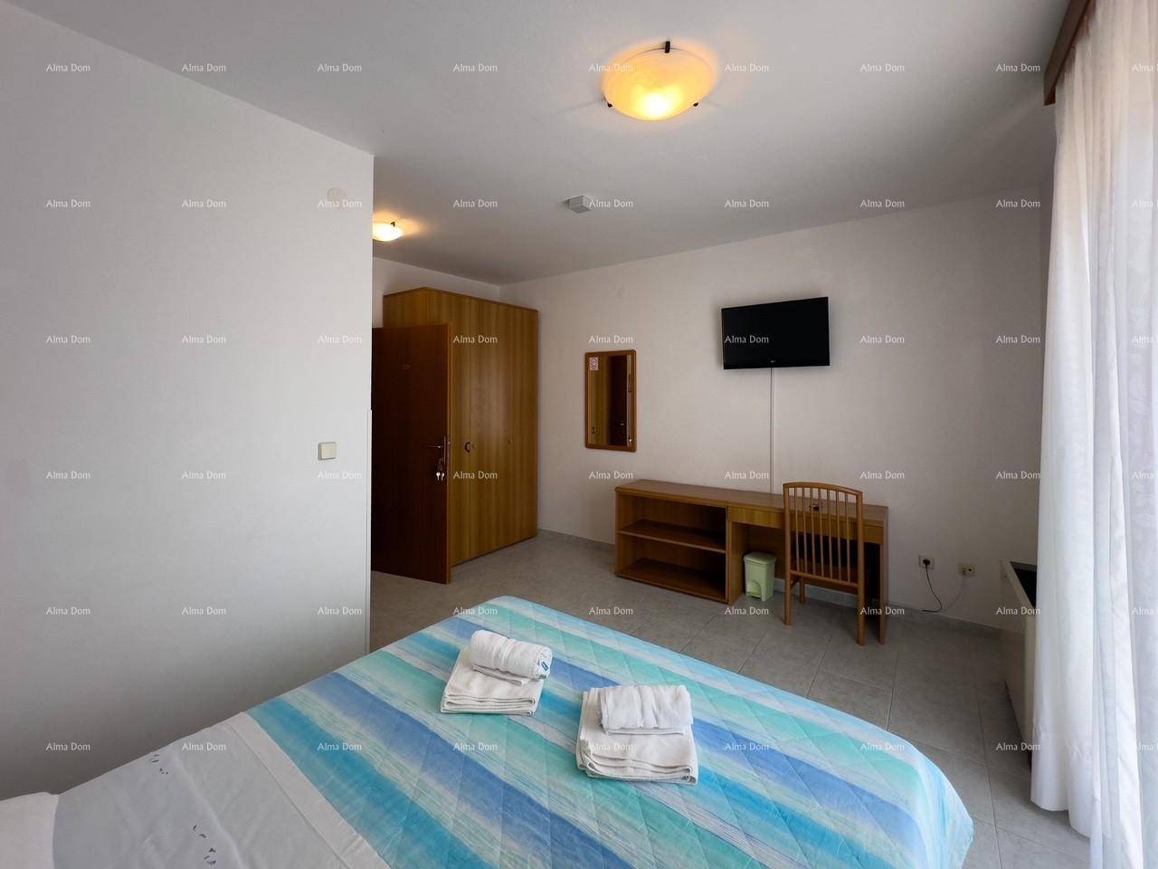 Schlafzimmer mit Doppelbett, Schreibtisch und Kleiderschrank, hell und funktional eingerichtet.