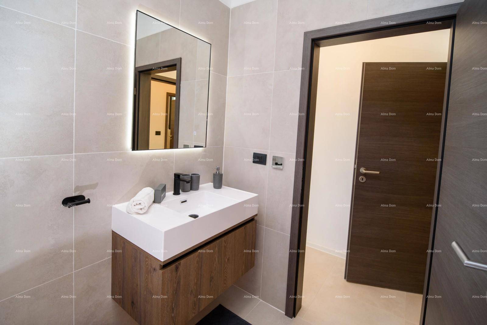 Elegantes Badezimmer mit modernem Waschtisch, beleuchtetem Spiegel und dunkler Holztür.