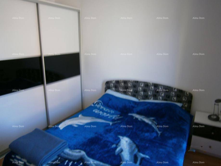 Schlafzimmer mit Doppelbett, Schiebetürenschrank und Holzboden.