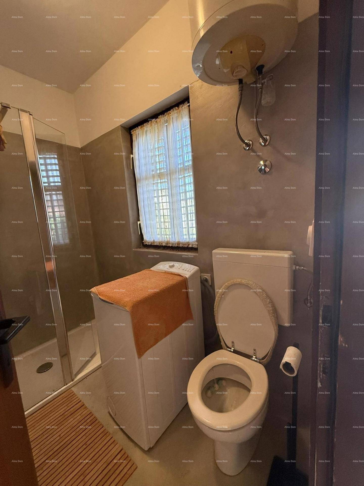 Badezimmer mit Toilette, Waschmaschine und Fenster für natürliche Belüftung.