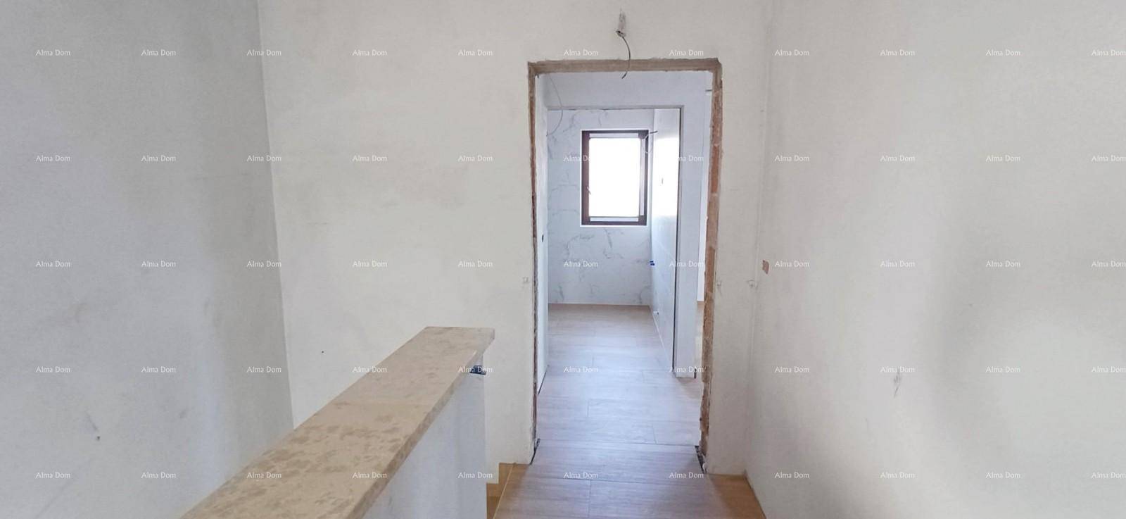 Heller Flurbereich im Obergeschoss mit Holzboden und Fenster, noch im Rohbau.