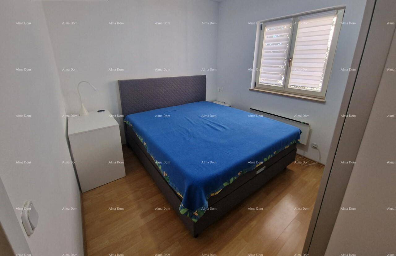 Helles Schlafzimmer mit Holzboden, Doppelbett und Nachttisch neben dem Fenster.