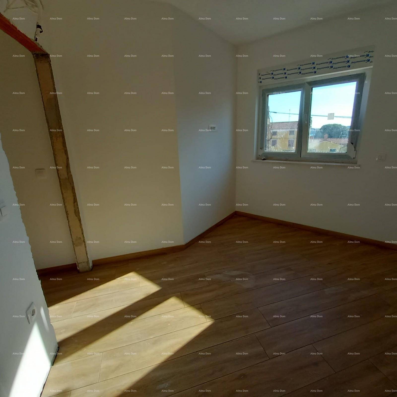 Helles Zimmer mit neu verlegten Fliesen in Holzoptik und einem Fenster mit Tageslicht.