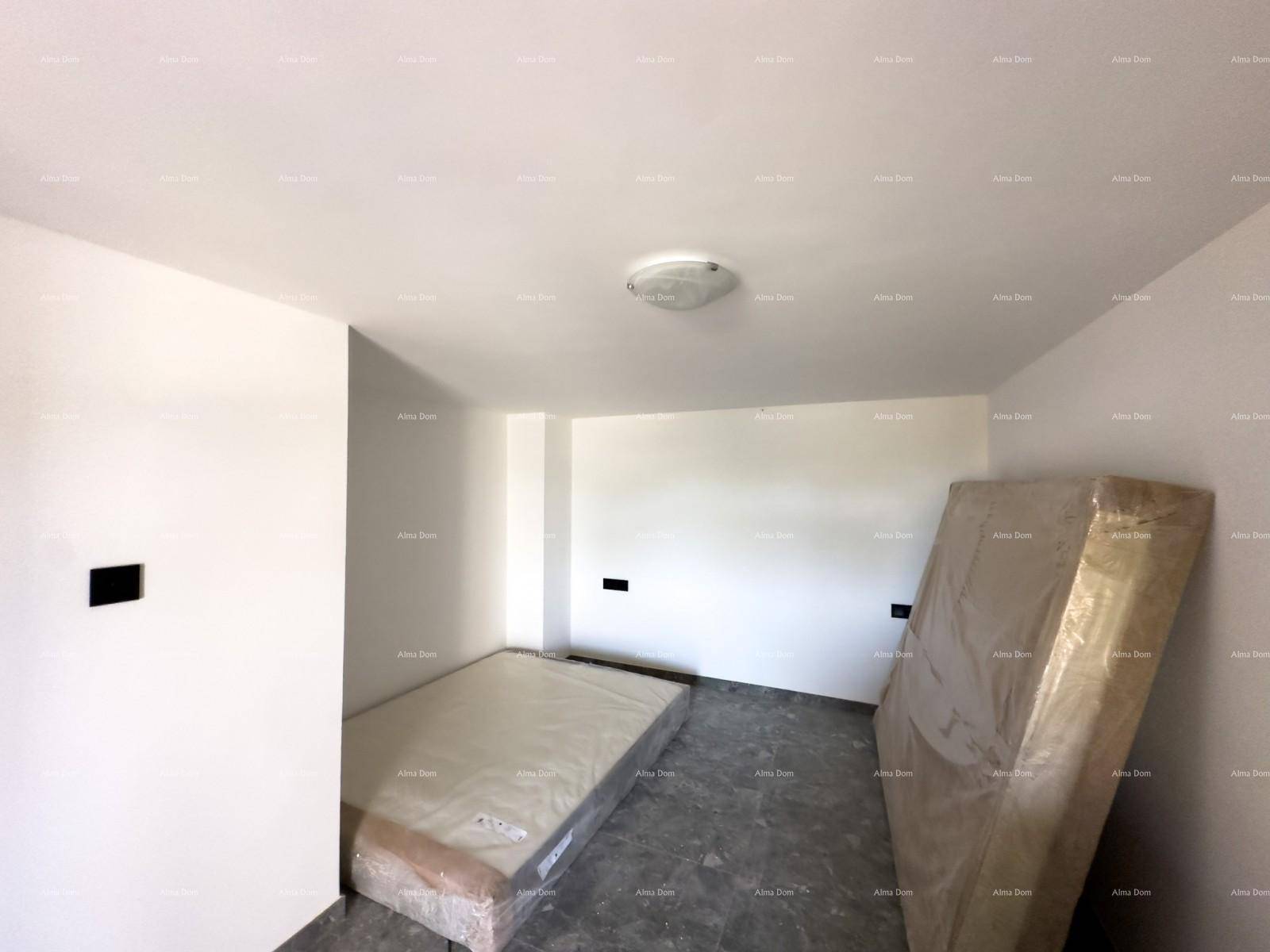 Helles Schlafzimmer mit grauen Fliesen und einer Matratze, bereit zur Möblierung in einem Neubau.