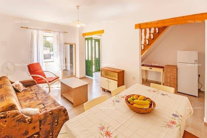 Heller Wohn- und Essbereich mit rustikalem Sofa, Esstisch und Zugang zu weiteren Räumen.