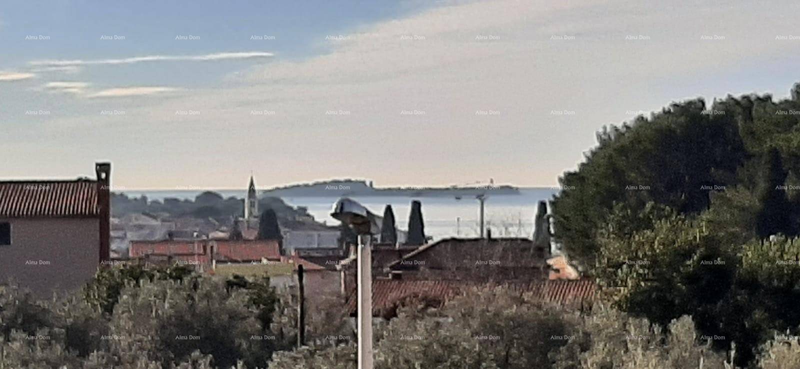 Weiter Blick über die Dächer der Stadt zum Meer und einer Insel am Horizont.