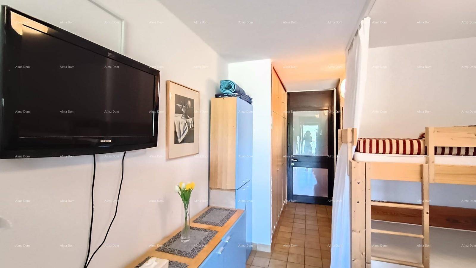 Schlafbereich mit Etagenbett und Fernseher an der Wand, praktisch eingerichtet.