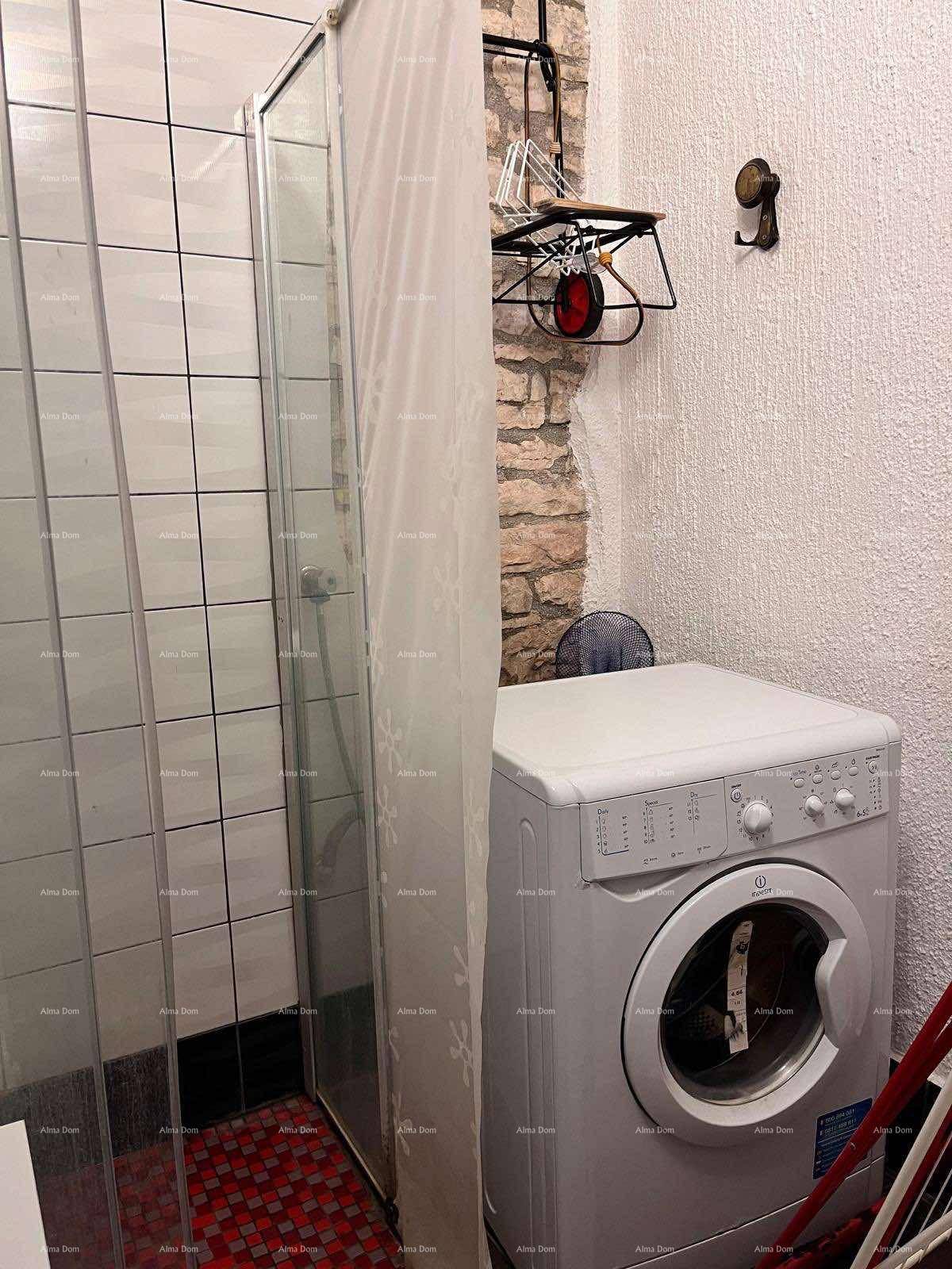Badezimmer mit Duschkabine und einer praktischen Waschmaschine, ideal für den täglichen Gebrauch.