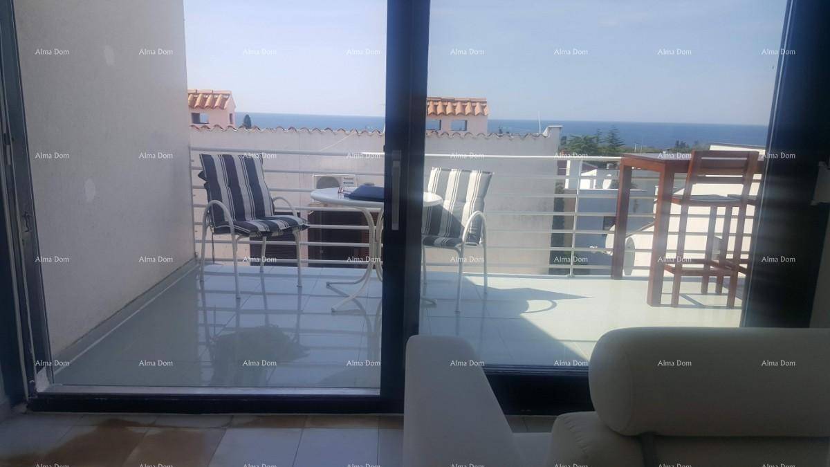 Innenraum mit Blick auf einen Balkon, der mit Sitzgelegenheiten und Meerblick ausgestattet ist.