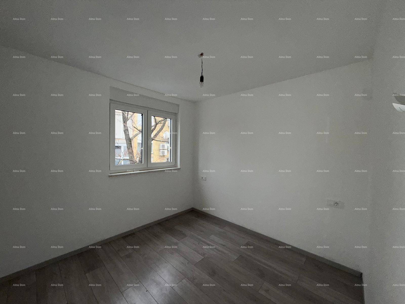 Helles Schlafzimmer mit Holzplankenboden und großem Fenster, bietet viel Tageslicht.