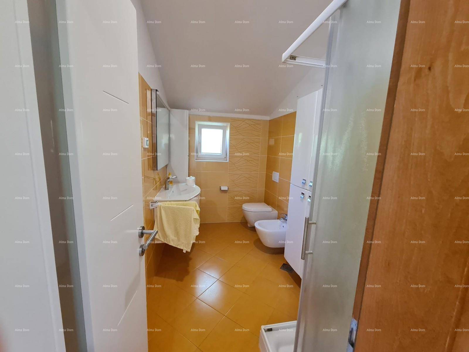 Funktionales Badezimmer mit Fenster, Dusche, WC, Bidet und einem Waschtisch mit Spiegel.