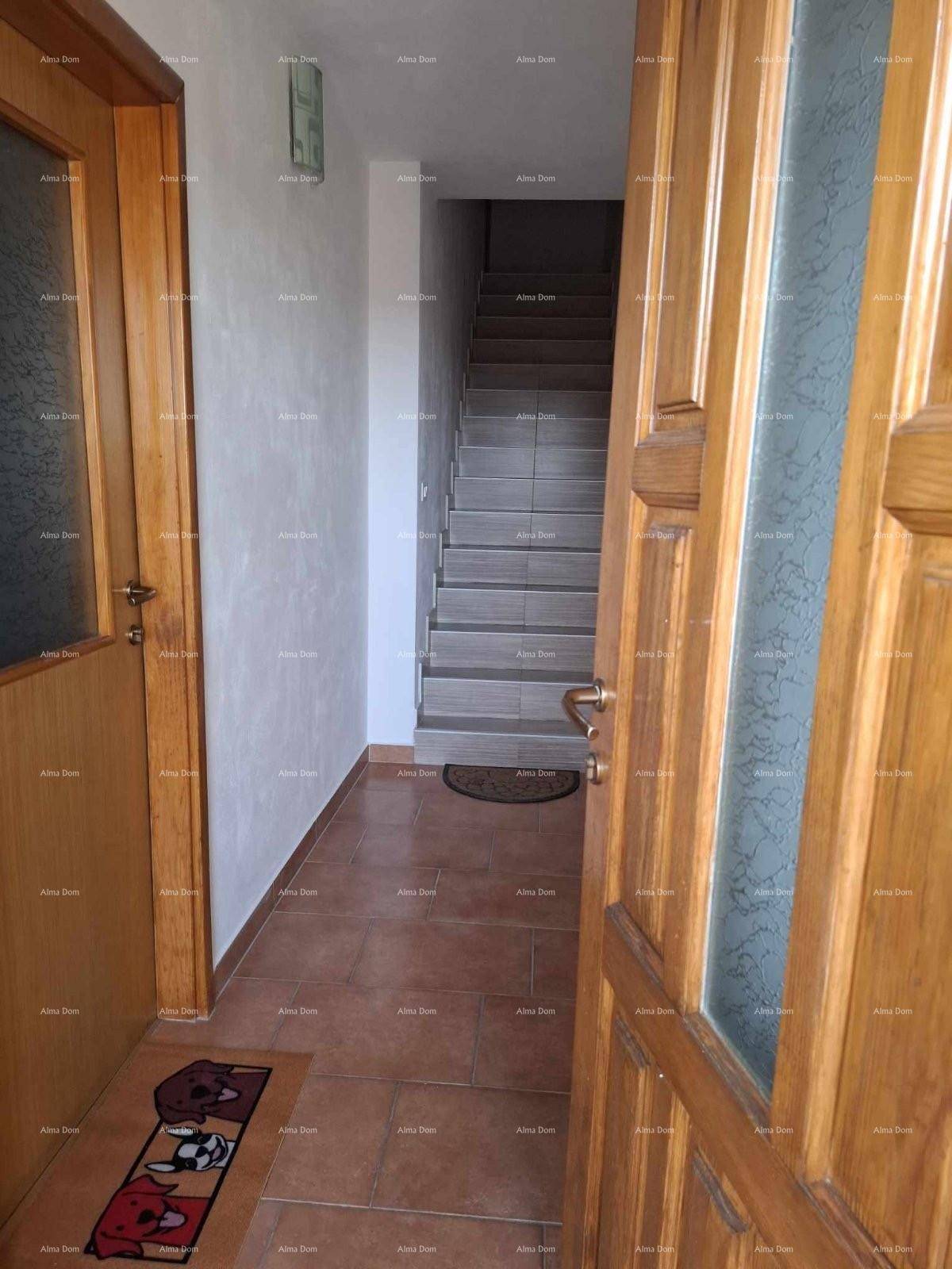 Heller Flur mit Fliesenboden und Treppe, die in die oberen Stockwerke führt.