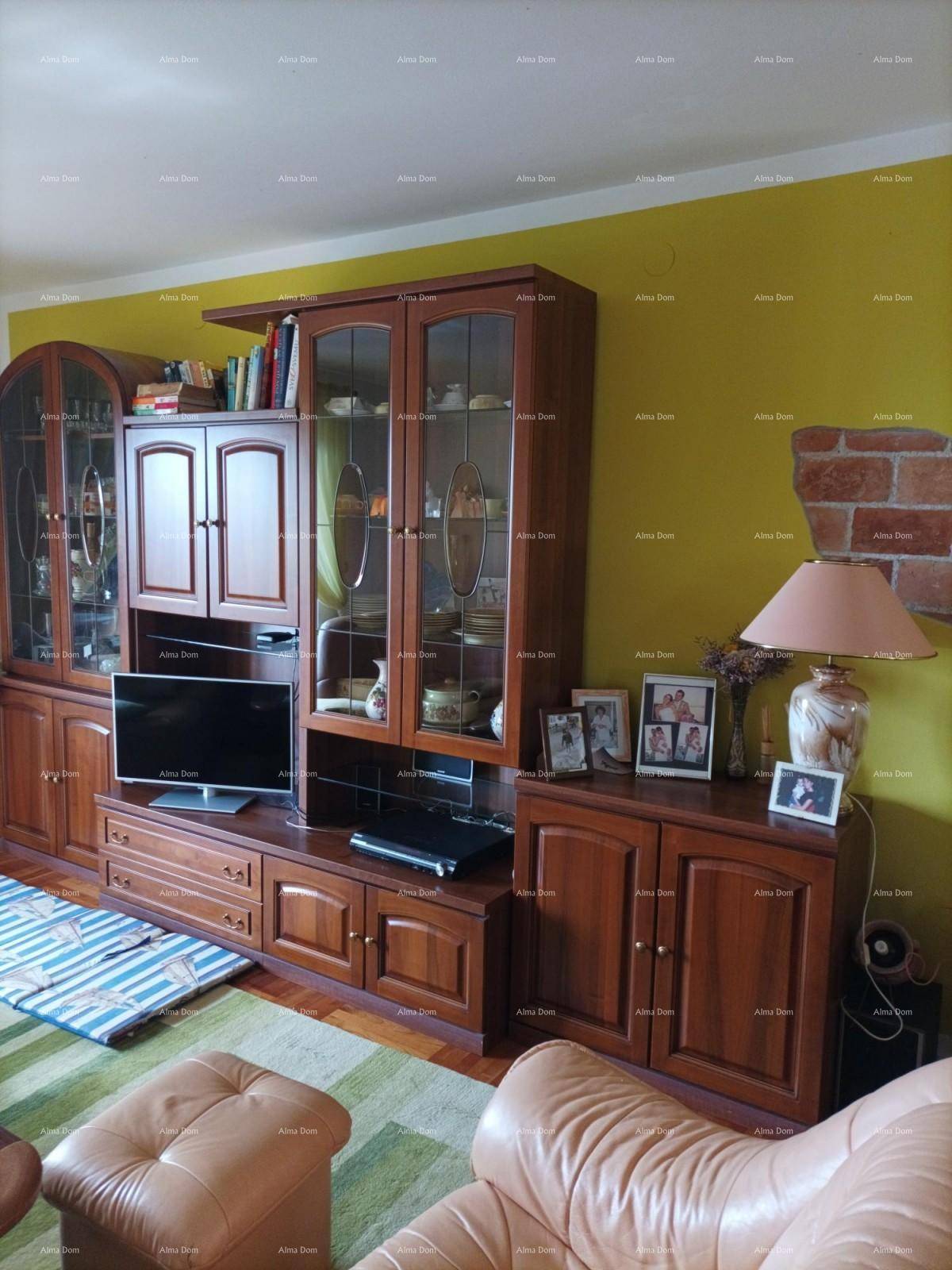 Wohnzimmer mit großer Holzschrankwand, Fernseher und bequemer Ledercouch vor gelben Wänden.