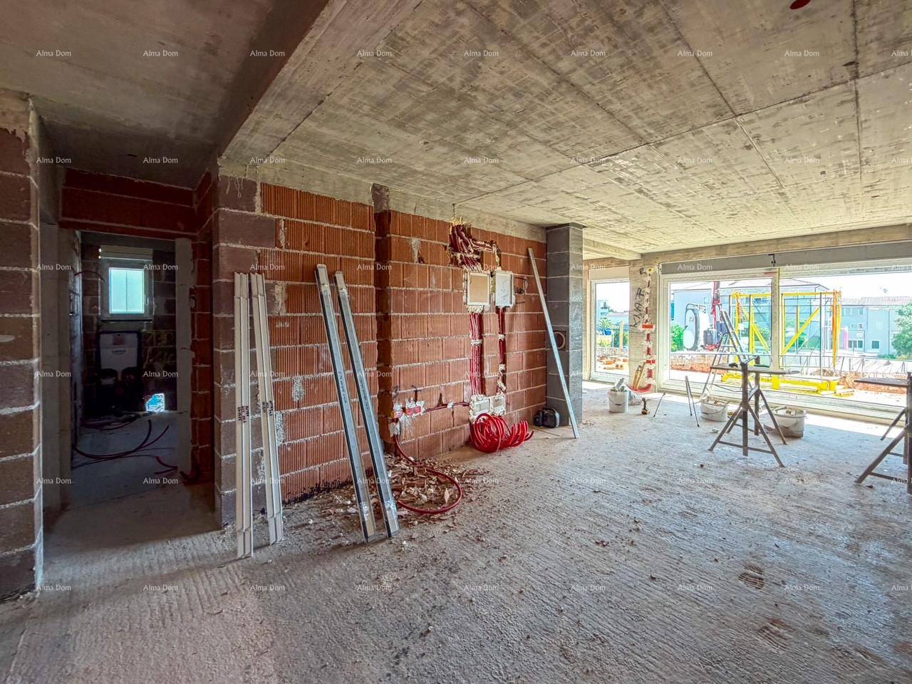 Rohbau einer Wohnung mit Ziegelwänden, Betonboden und Blick auf die Baustelle draußen.