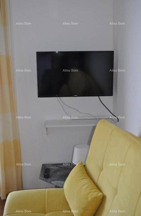 Gemütlicher Wohnbereich mit gelbem Sofa und wandmontiertem Fernseher.