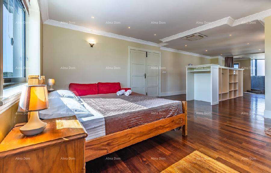 Geräumiges Schlafzimmer mit Holzboden, Doppelbett und offenem Ankleidebereich.