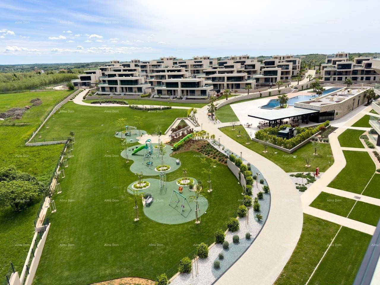 Weitläufige Wohnanlage mit großem Spielplatz, grünen Rasenflächen und einem Poolbereich im Hintergrund.