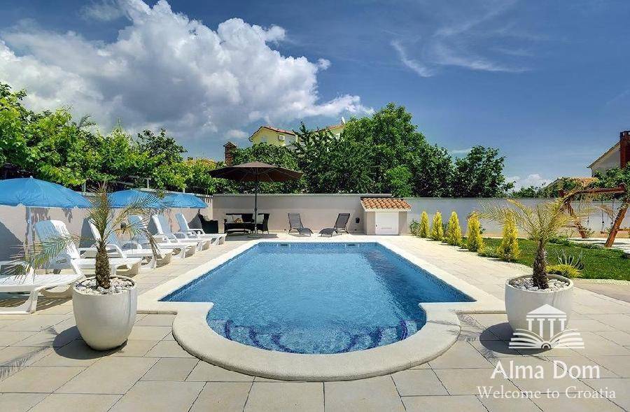 Einladender Poolbereich mit blauen Sonnenschirmen und bequemen Liegestühlen für sonnige Tage.