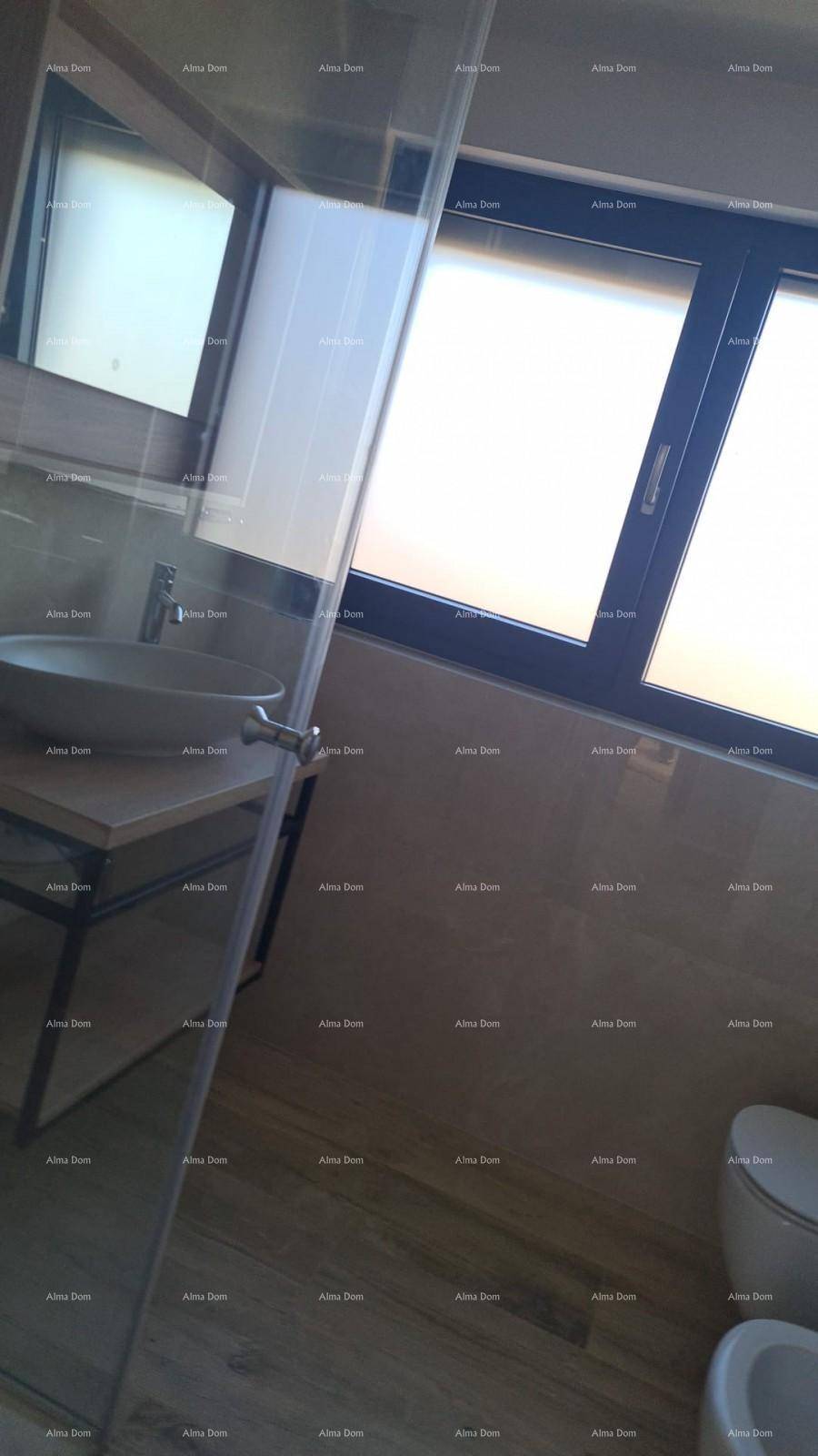 Modernes Badezimmer mit Waschbecken, Toilette und großem Fenster für viel Helligkeit.